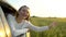 Happy young travel smiling beautiful young woman enjoying road trip in summer nature wheat field. Girl holding arm, puts