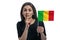 Happy young white woman holding flag of Mali and holds a finger to her lips isolated on a white background