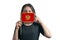 Happy young white woman holding flag Montenegro flag and covers her face with it isolated on a white background