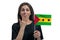 Happy young white woman holding flag of Sao Tome and Principe and covers her mouth with her hand isolated on a white background