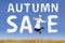 Happy young woman with autumn sale sign