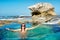 Happy young woman on awesome rocky beach