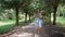 Happy young woman beautifully walks along path in park with bouquet of flowers. Girl posing with bouquet of wildflowers in nature