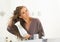 Happy young woman blow drying hair in bathroom