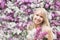 Happy young woman with a bouquet on a background of blooming lilacs