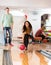 Happy Young Woman Bowling in Club