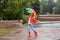 Happy young woman with bright umbrella under rain