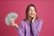 Happy young woman with cash money on background