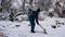 Happy young woman cleans snow in the garden near the house. Portrait of a girl with a snow shovel in her hands. Happy girl removes