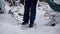 Happy young woman cleans snow in the garden near the house. Portrait of a girl with a snow shovel in her hands. Happy girl removes