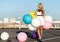 Happy young woman with colorful latex balloons