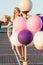 Happy young woman with colorful latex balloons