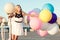 Happy young woman with colorful latex balloons