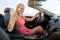 Happy young woman in convertible car waving hand