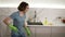 Happy young woman cute housewife is washing floor with mop and dancing and singing at home in kitchen enjoying housework
