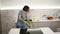 Happy young woman cute housewife is washing floor using protective gloves at home in kitchen enjoying housework. People