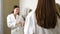 Happy young woman dancing in front of bathroom mirror in the morning. Funny charming woman in white robe dancing happily