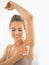 Happy young woman deodorant on underarm