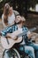 Happy Young Woman and Disabled Man with Guitar