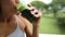 Happy Young Woman Drinking Fresh Green Juice At Park