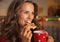 Happy young woman eating christmas cookie