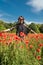 Happy young woman enjoying freedom at nature, poppy field