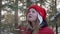 Happy young woman enjoying hot tea in snowy winter forest at holiday walk. Portrait beautiful girl in red hat drinking