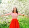 Happy young woman enjoying smell in flowering spring garden