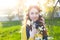 Happy young woman enjoying smell flowers over spring garden background