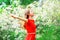 Happy young woman enjoys smell in flowering garden