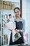 happy young woman florist working in flower shop holding flannel flower