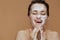 Happy young woman with foaming face wash washing face