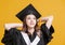 Happy young woman in graduation gowns and looking away