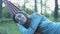 Happy young woman on a hammock. Smiling beautiful girl relaxes in nature, lying on a hammock.