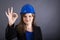 Happy young woman with hardhat showing ok sign