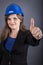 Happy young woman with hardhat showing ok sign