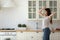 Happy young woman have fun dancing in kitchen