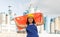 Happy young woman in helmet holding flag of China against background of factory