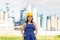 Happy young woman with helmet posing against background of factory