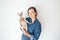 Happy young woman with her Devon Rex cat. Young woman is holding and hugging her cute curious Devon Rex cat. Cat is feeling