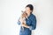 Happy young woman with her Devon Rex cat. Young woman is holding and hugging her cute curious Devon Rex cat. Cat is feeling