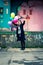 Happy young woman holding balloons jumping high