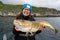 Happy young woman holding big arctic cod. Norway happy fishing. Fisherwoman with cod fish in hands