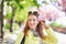 Happy young woman holding cherry blossom in hair at springtime