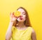 Happy young woman holding a half orange