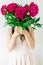 Happy young woman holding in hands peony bouquet. Woman in pink dress. Sweet romantic moment