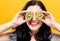 Happy young woman holding kiwis