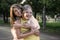 Happy young woman hugs her daughter outdoors with a smile. Mother and her grown up daughter