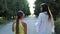 Happy young woman hugs her daughter outdoors with a smile. Mother and her grown up daughter