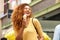 Happy young woman laughing with ice cream in the city